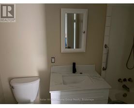 A white toilet sits next to a sink in a bathroom.