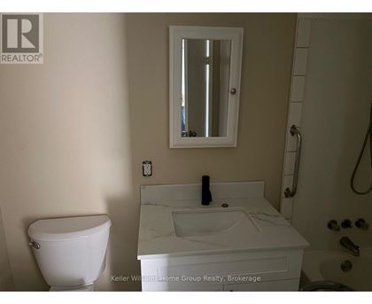 A white toilet sits next to a sink in a bathroom.