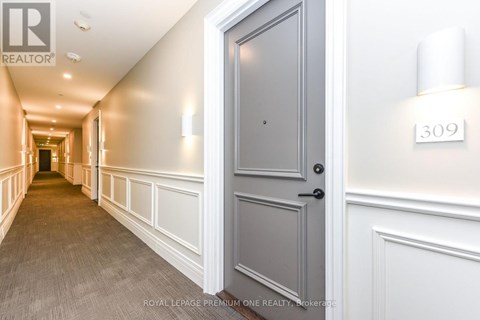 A hallway with a door on the right and a number 309 on the wall.