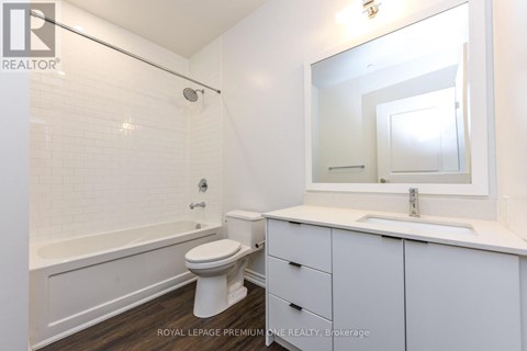 A white bathroom with a toilet, sink, and bathtub.