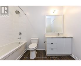 A white bathroom with a toilet, sink, and bathtub.