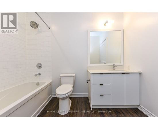 A white bathroom with a toilet, sink, and bathtub.