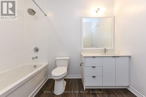 A white bathroom with a toilet, sink, and bathtub.