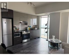 A modern kitchen with a refrigerator, oven, and sink.