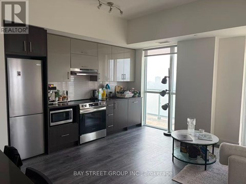 A modern kitchen with a refrigerator, oven, and sink.