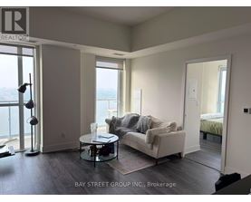 A living room with a couch, a table, and a view of the water.