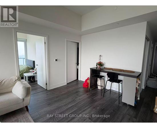 A living room with a couch, a chair, and a dining table.
