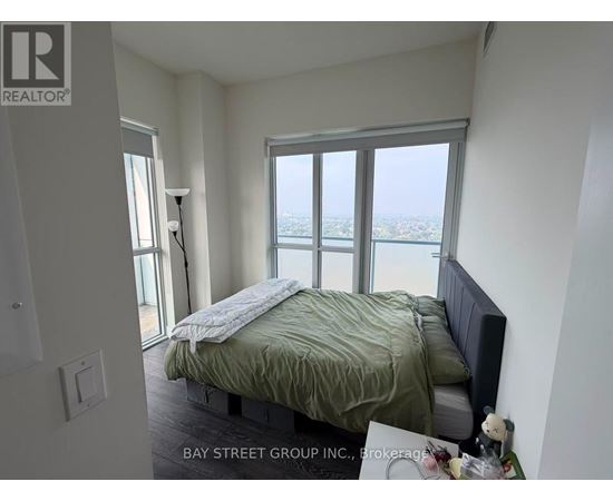 A bedroom with a bed and a window overlooking the city.