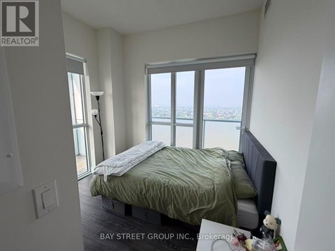 A bedroom with a bed and a window overlooking the city.