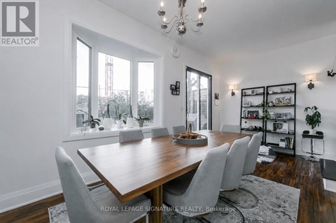 A dining room with a wooden table and chairs.