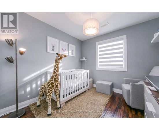 A baby's room with a giraffe toy and a white crib.
