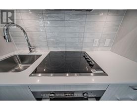 A modern kitchen with a stove top oven and a sink.