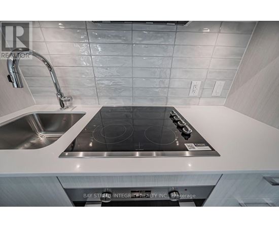 A modern kitchen with a stove top oven and a sink.