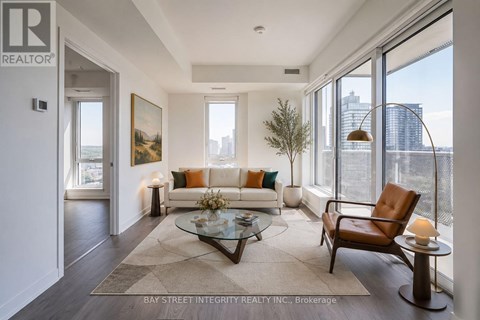 A living room with a couch, a chair, a coffee table, and a painting on the wall.