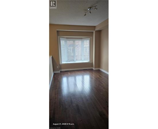 A room with a window and wooden flooring.
