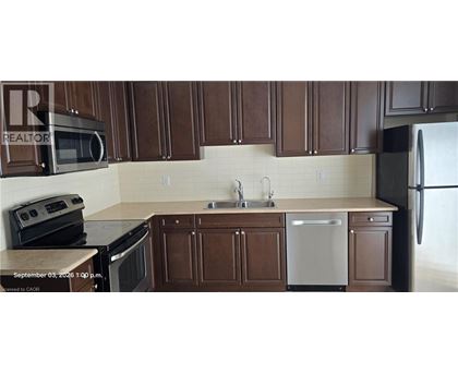 A kitchen with brown cabinets and a white dishwasher.