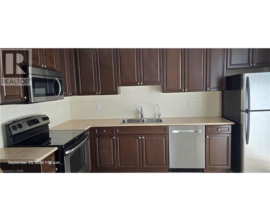 A kitchen with brown cabinets and a white dishwasher.