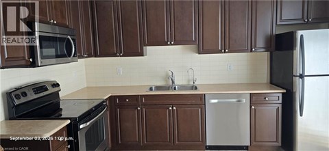A kitchen with brown cabinets and a white dishwasher.