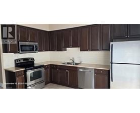 A kitchen with brown cabinets and a white refrigerator.