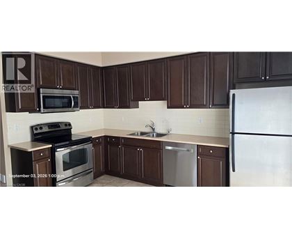 A kitchen with brown cabinets and a white refrigerator.