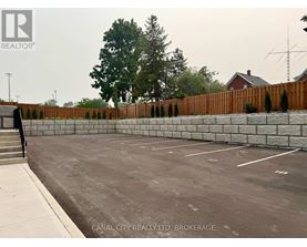 A parking lot with a fence and a building in the background.
