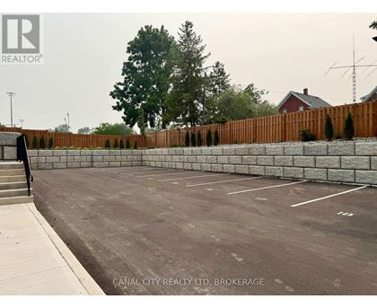 A parking lot with a fence and a building in the background.