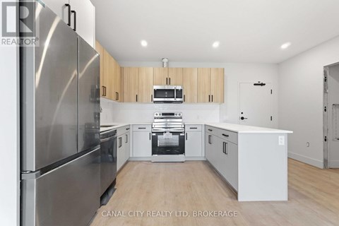A modern kitchen with wooden cabinets and stainless steel appliances.