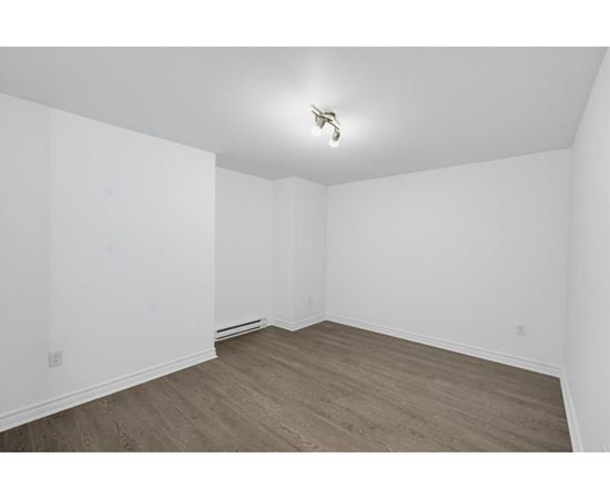 A room with wooden flooring and white walls.