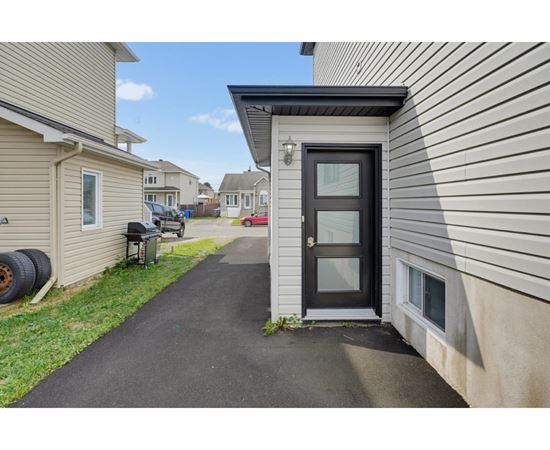 A black door is on the side of a house.
