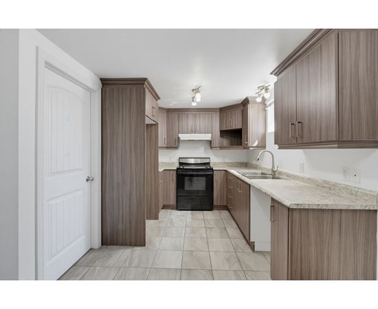 A kitchen with brown cabinets and a black oven.