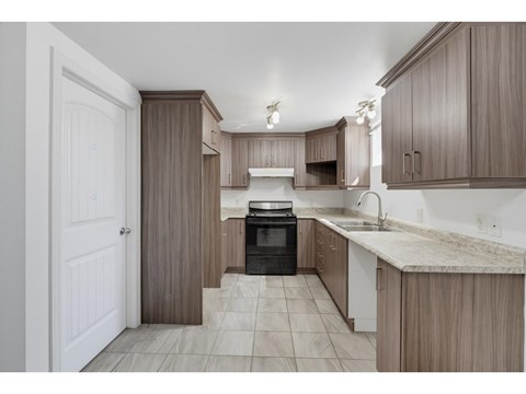 A kitchen with brown cabinets and a black oven.