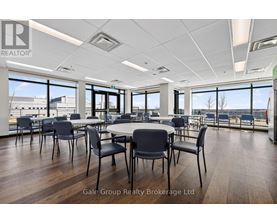 A conference room with a table surrounded by chairs and a view of the outside.