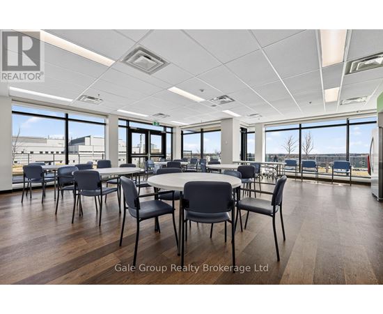 A conference room with a table surrounded by chairs and a view of the outside.