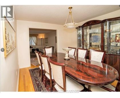 A dining room with a wooden table and chairs.