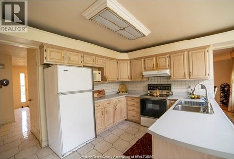 A kitchen with a white refrigerator and wooden cabinets.
