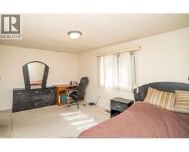 A bedroom with a bed, desk, and chair.