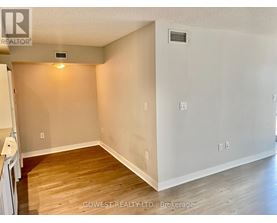 A room with wooden flooring and white walls, with a small light on the wall.