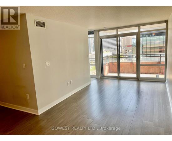 A room with a sliding glass door leading to a balcony.