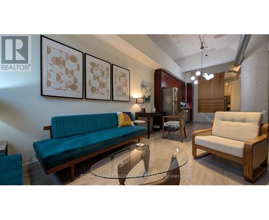 A living room with a couch, chairs, and a coffee table.