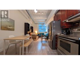A modern kitchen with stainless steel appliances and wooden cabinets.