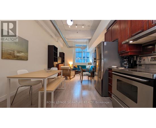 A modern kitchen with stainless steel appliances and wooden cabinets.