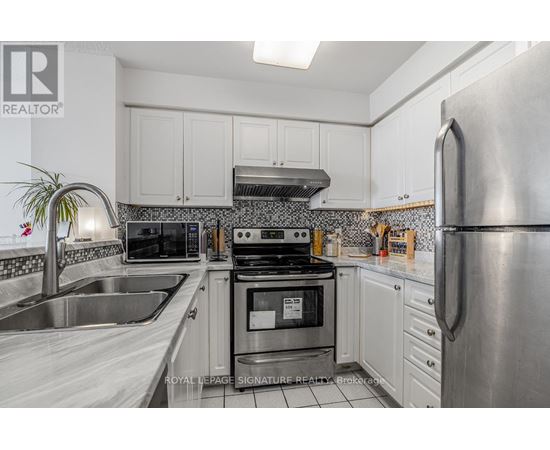 A kitchen with white cabinets and a stainless steel refrigerator.