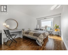 A bedroom with a bed, desk, and chair.