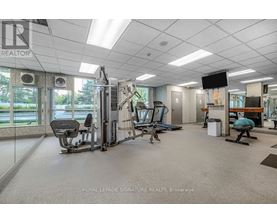 A gym with a variety of equipment including a treadmill, weights, and a television.