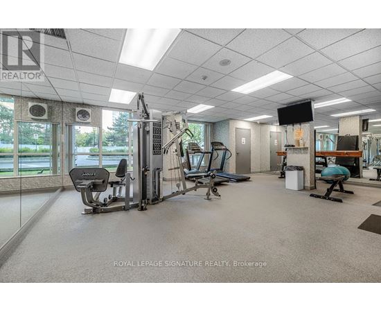 A gym with a variety of equipment including a treadmill, weights, and a television.