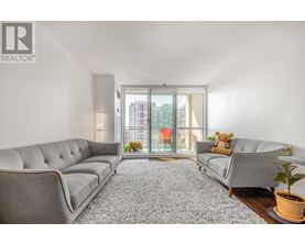 A living room with a grey sofa and a carpet.