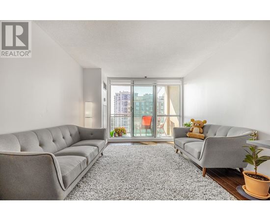 A living room with a grey sofa and a carpet.