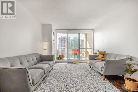 A living room with a grey sofa and a carpet.