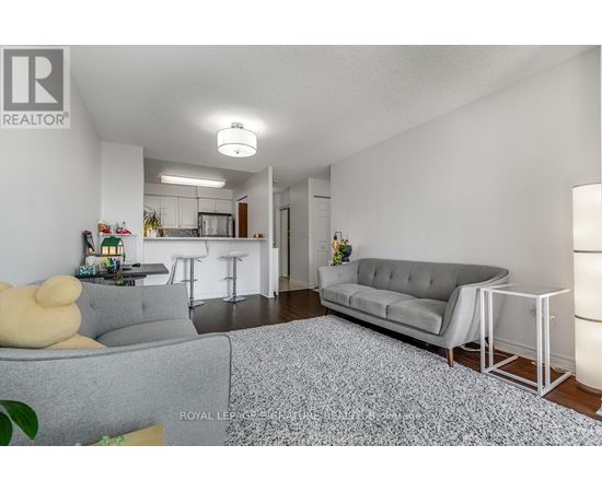 A living room with a grey couch and a white chair.