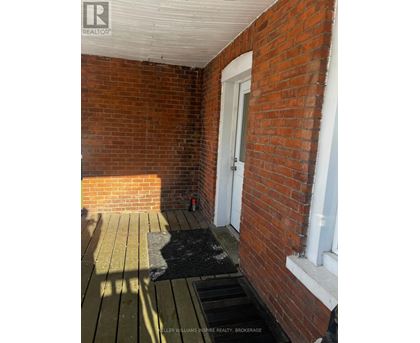 A brick wall with a door and a window.